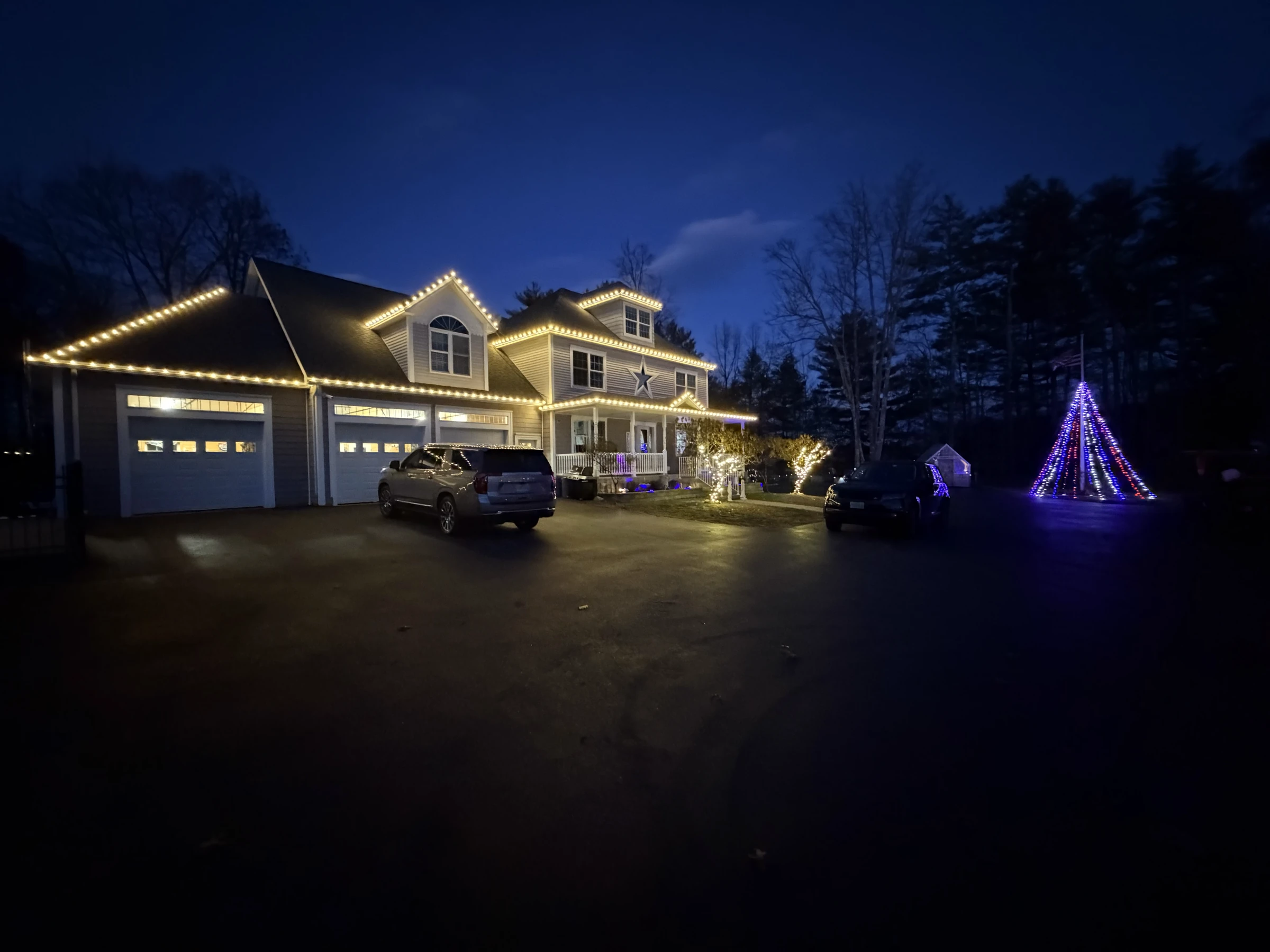 Christmas display with lit roofline, wrapped columns and window accents