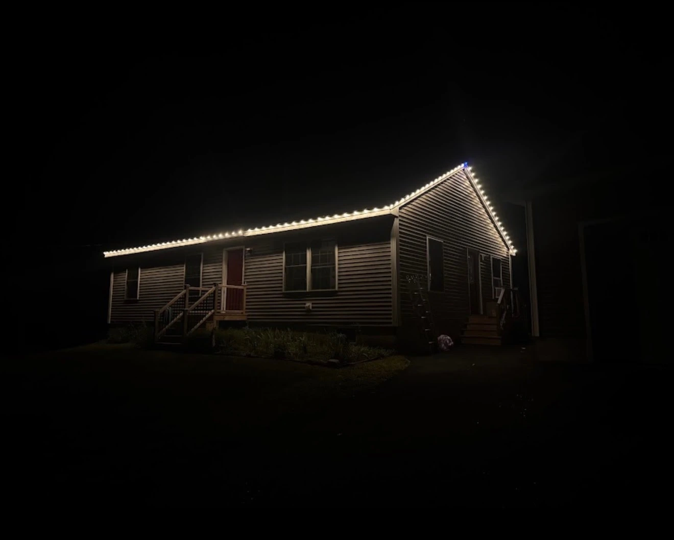 Warm white lights along a peaked roofline at night